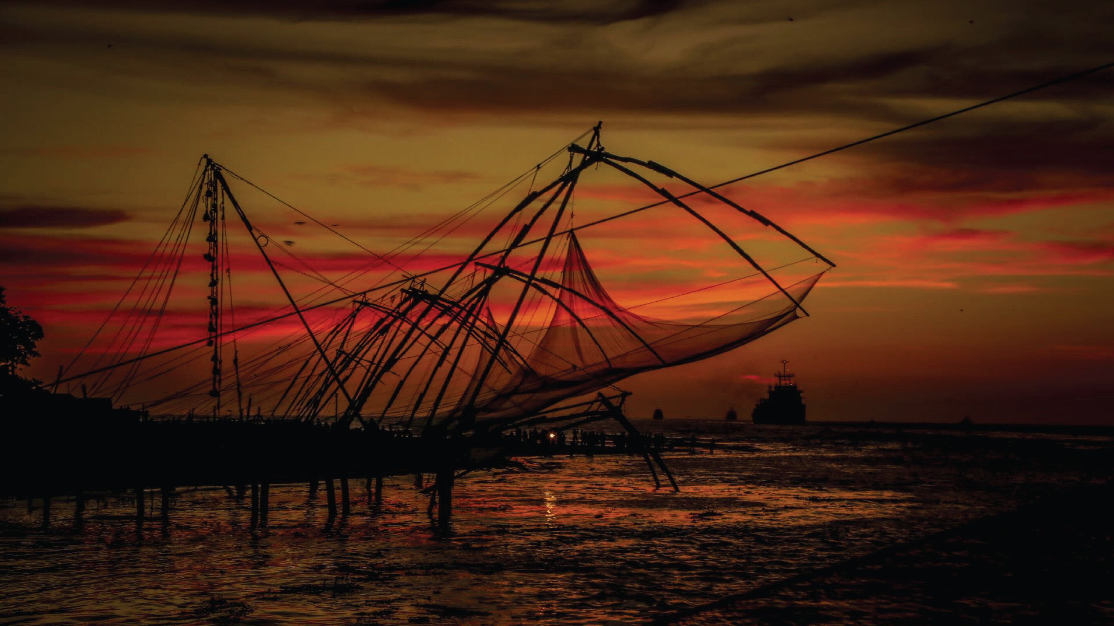 Una gran estructura de red sobre el agua al atardecer.