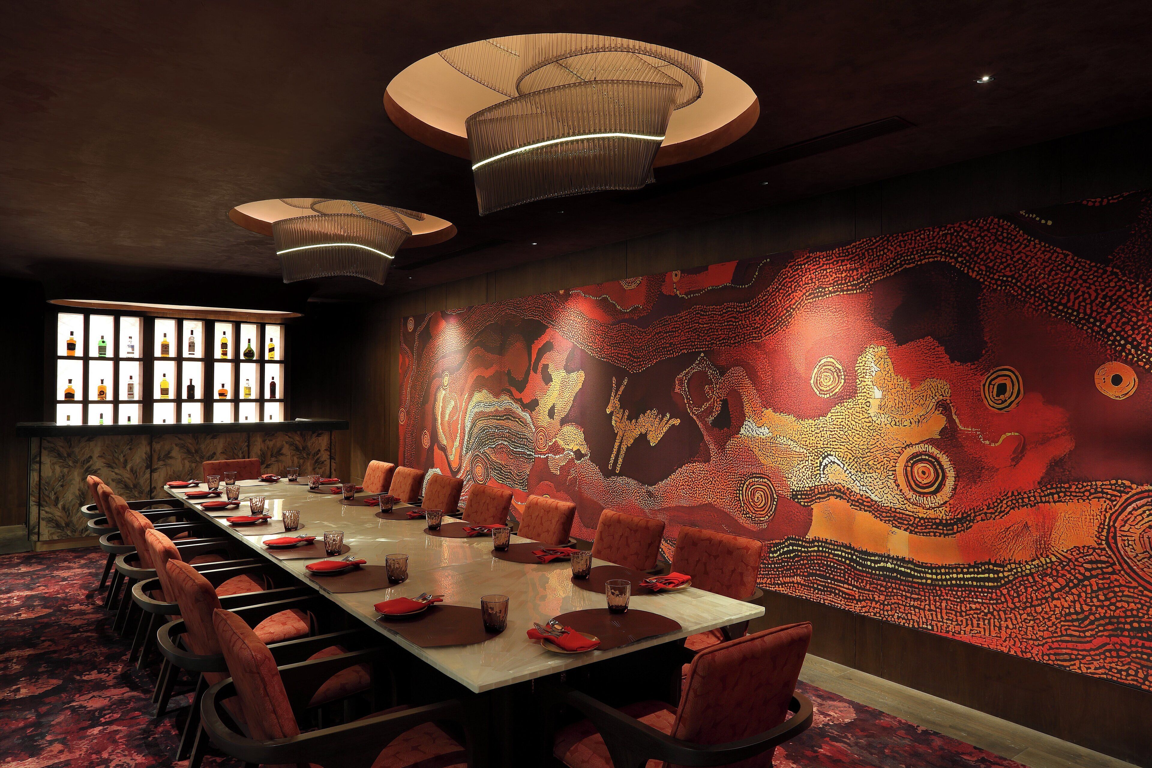 A conference room with a long table, chairs, and a large wall mural.
