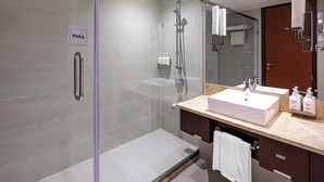 A modern bathroom with a glass-enclosed shower, a sink with a vanity, and a mirror.