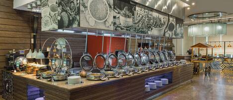 A buffet setup with various dishes and serving utensils.