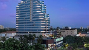 A multi-story hotel with a modern design, featuring a prominent signage at the top. - Holiday Inn Cochin by IHG (Kanayannur)