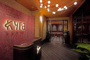 A reception area with a modern design, featuring a prominent reception desk and a unique ceiling light fixture. - Holiday Inn Cochin by IHG (Kanayannur)