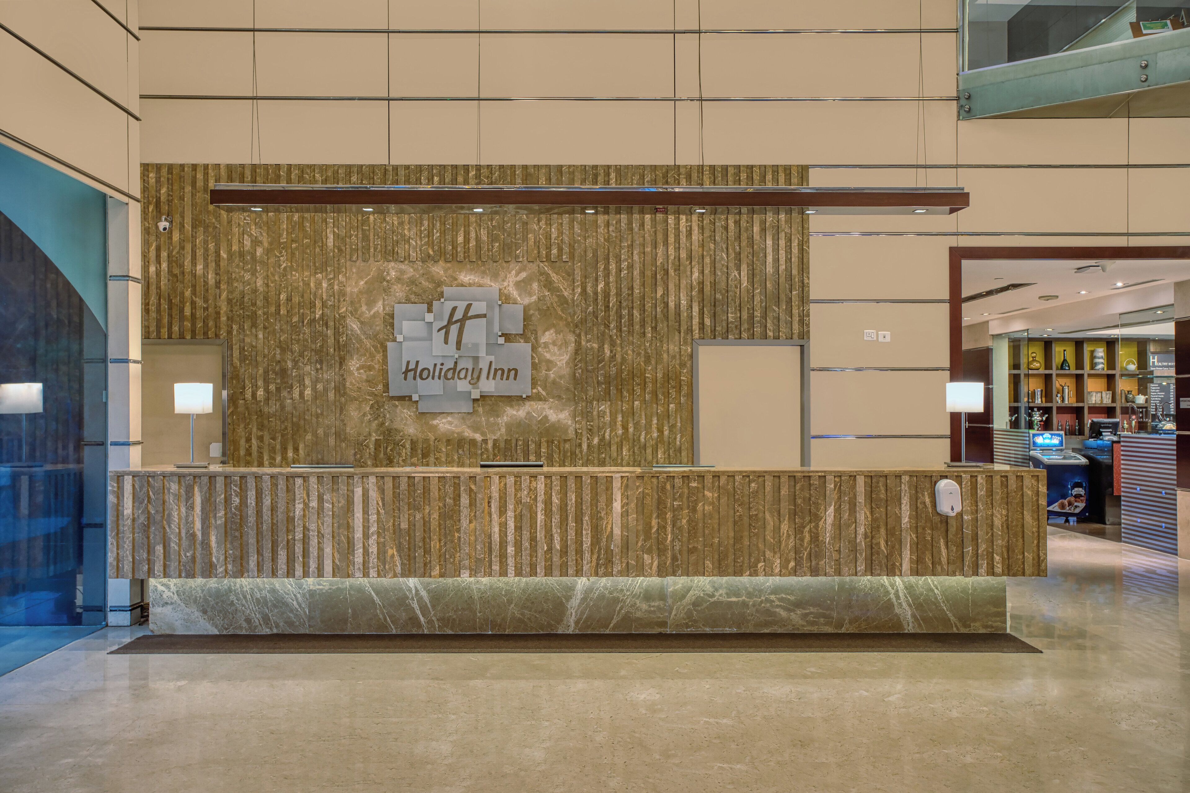 A reception desk with a marble top and a vertical wooden panel design.