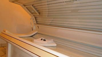 Una cama bronceadora con un panel de control y una toalla sobre ella.