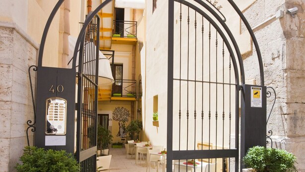 A gated entrance to a building with a number 40 sign, a small balcony, and potted plants. - Residence Cortile Mercè (Trapani)