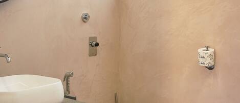 A bathroom with a white sink, a toilet, and a window above the toilet.