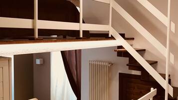 Un interior moderno con un dormitorio tipo loft, una escalera y un radiador.