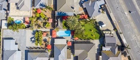 Vista aérea de una zona residencial con varias casas, una piscina y un estacionamiento.