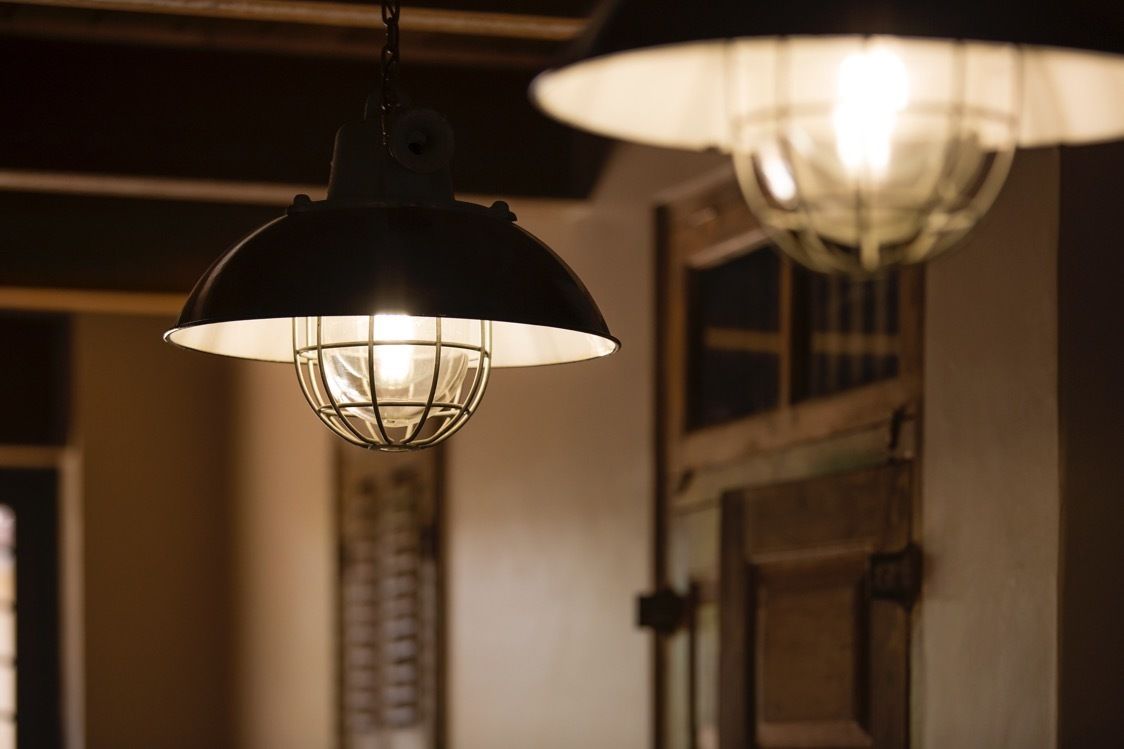 A hanging lamp with a metal frame and a white shade, suspended from the ceiling.