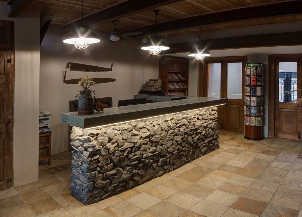 A reception area with a stone counter, wooden bookshelves, and a rustic ceiling.