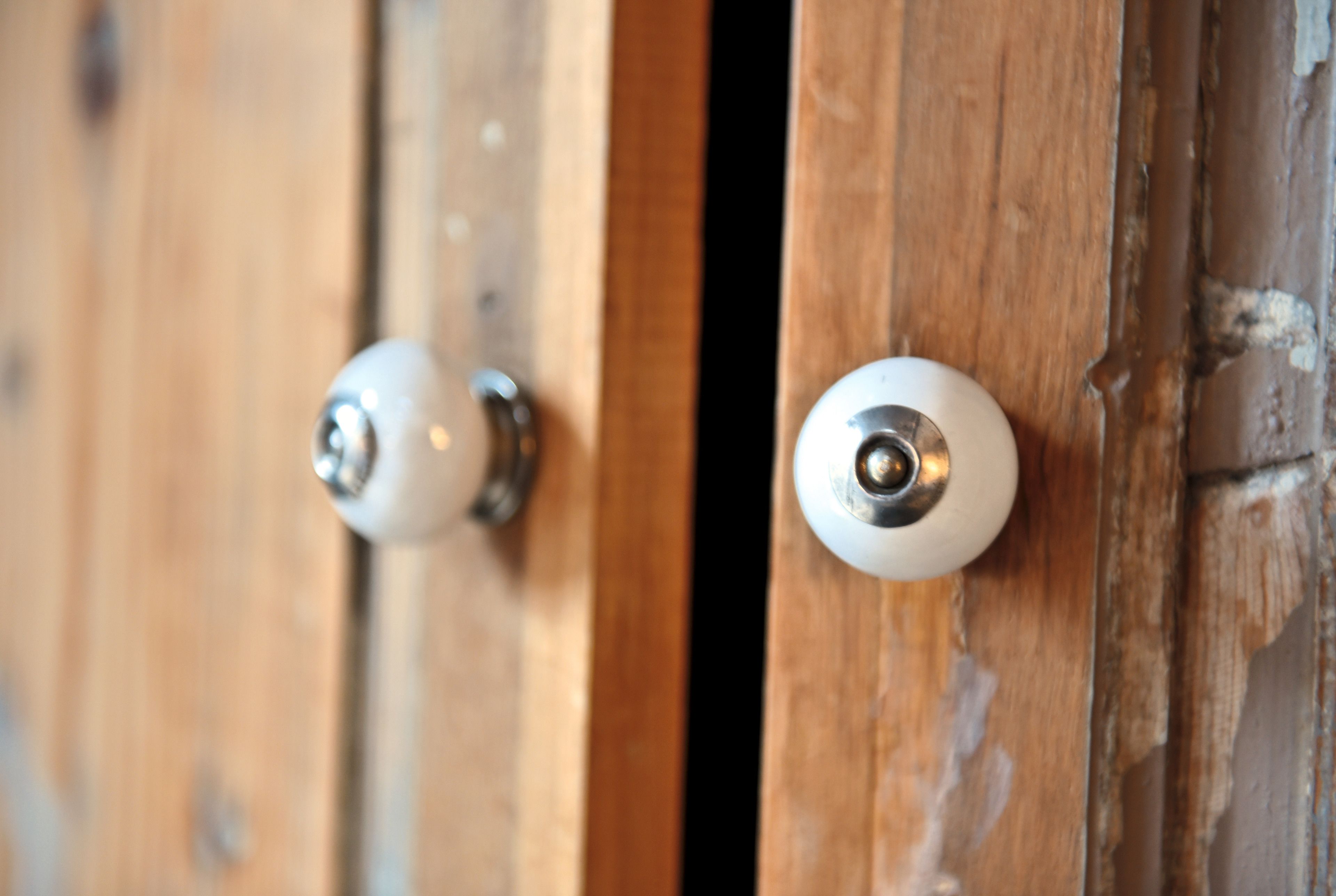 Une porte en bois avec deux poignées de porte rondes et blanches.
