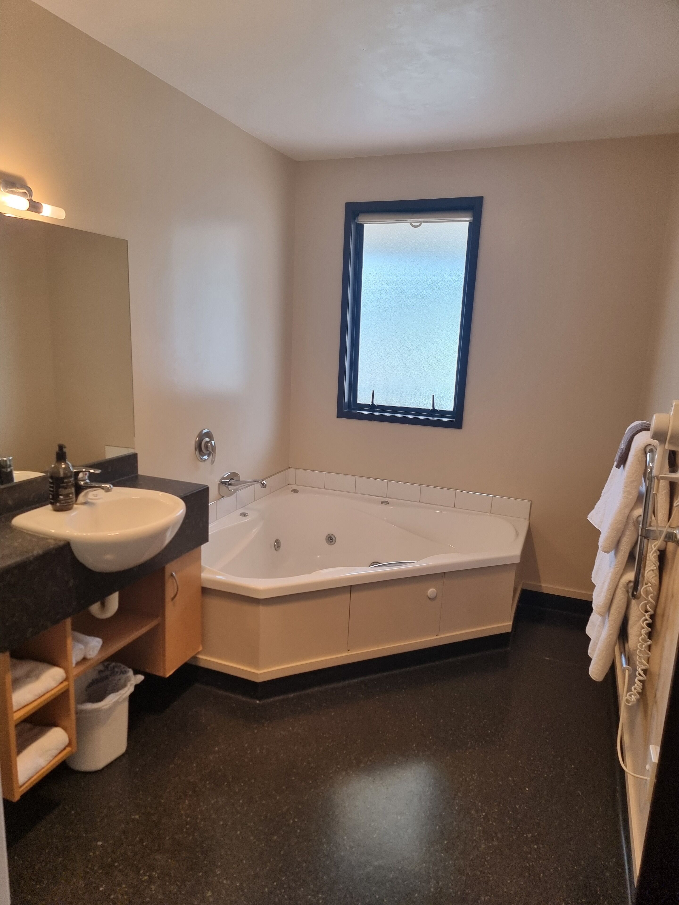 A modern bathroom with a freestanding bathtub, a vanity with a sink, and a large mirror.