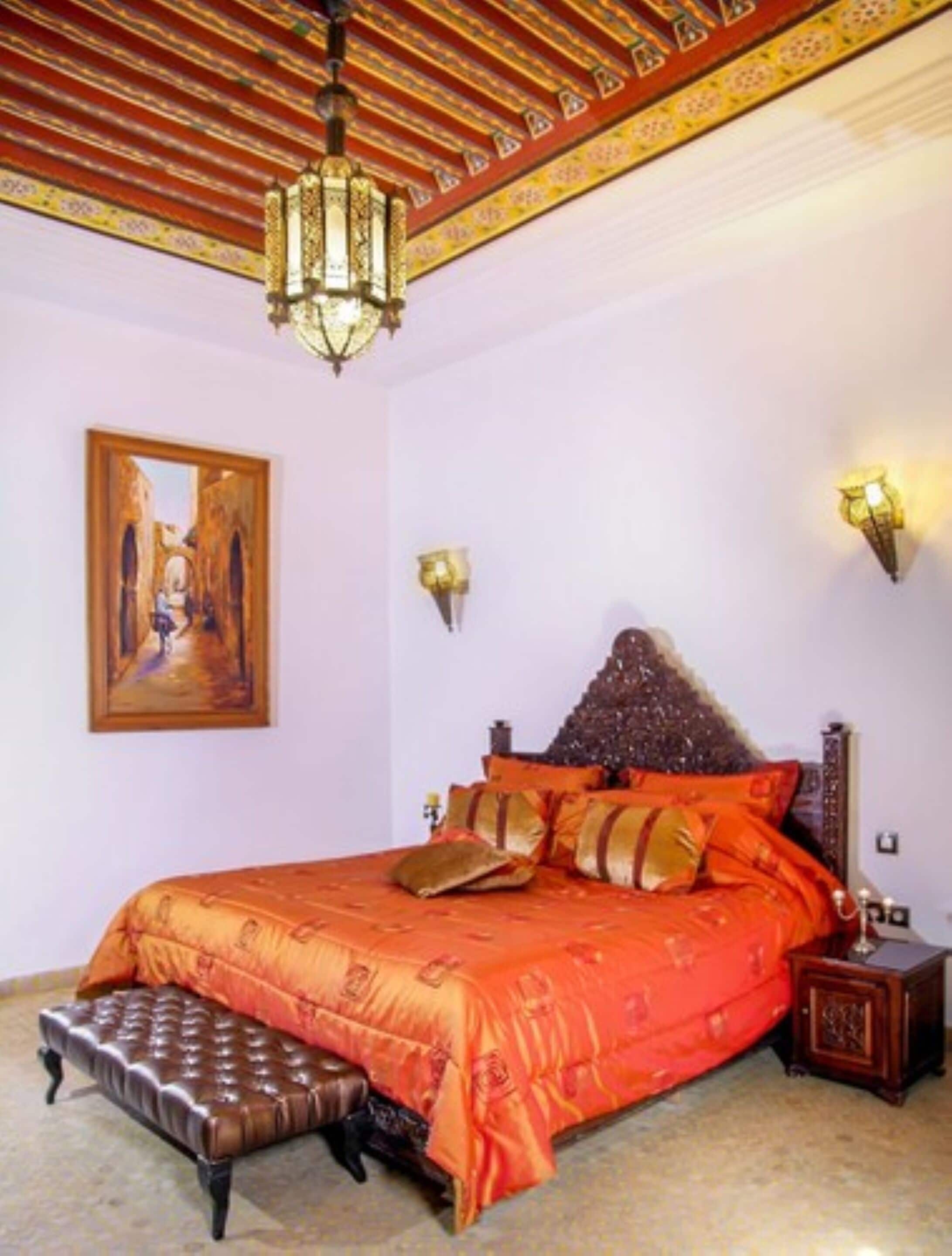 A bedroom with a large bed, a wooden headboard, and a painting on the wall.
