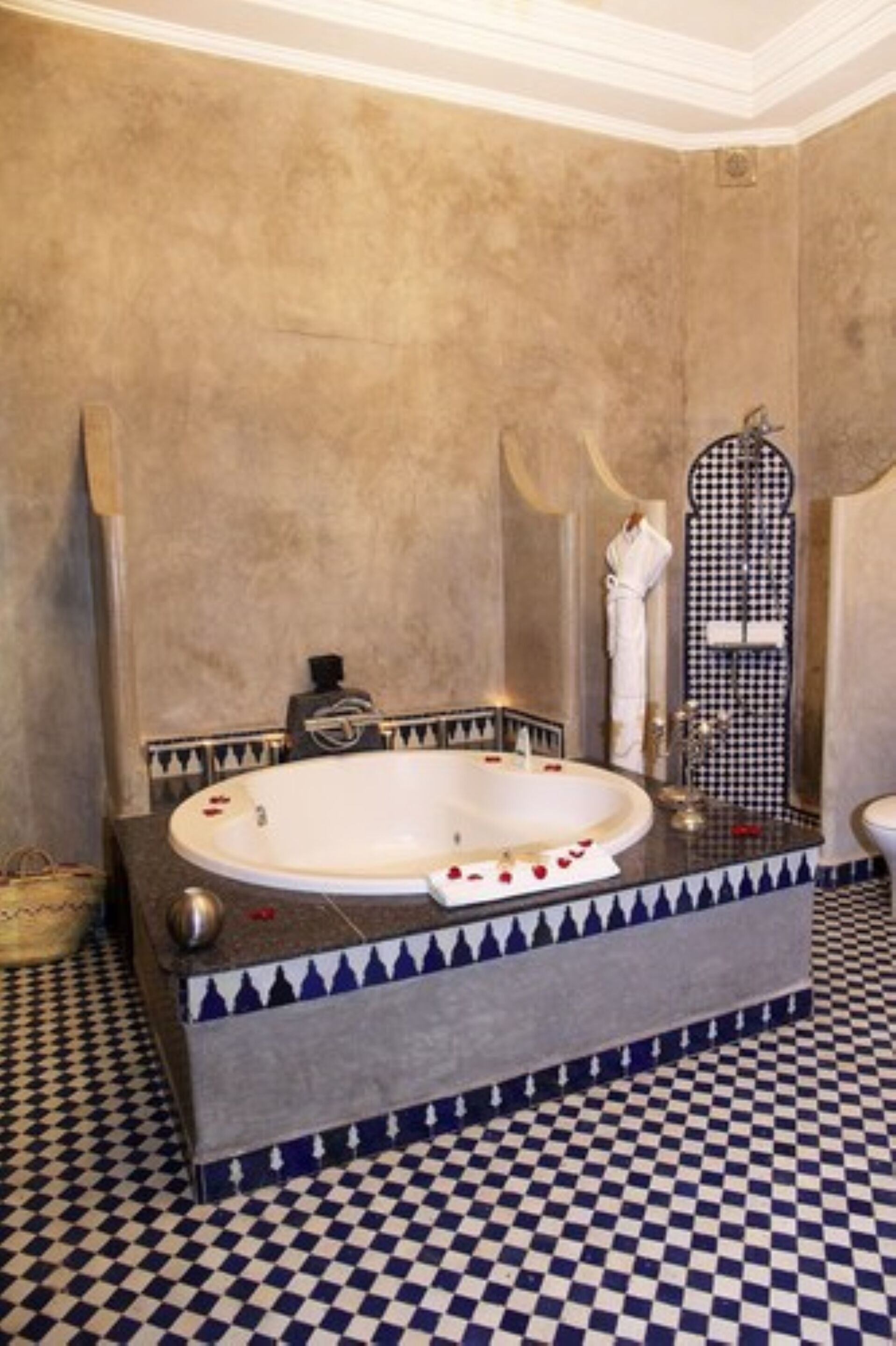 A bathroom with a large bathtub, checkered floor, and a mirror with a black and white checkered pattern.