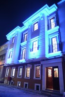 A multi-story building with illuminated blue lights outlining the windows and architectural details.