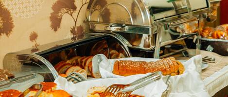 A buffet setup with various food items and a self-service coffee station.