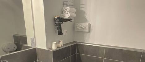 Une salle de bain moderne avec un lavabo blanc, des toilettes et un porte-serviettes.