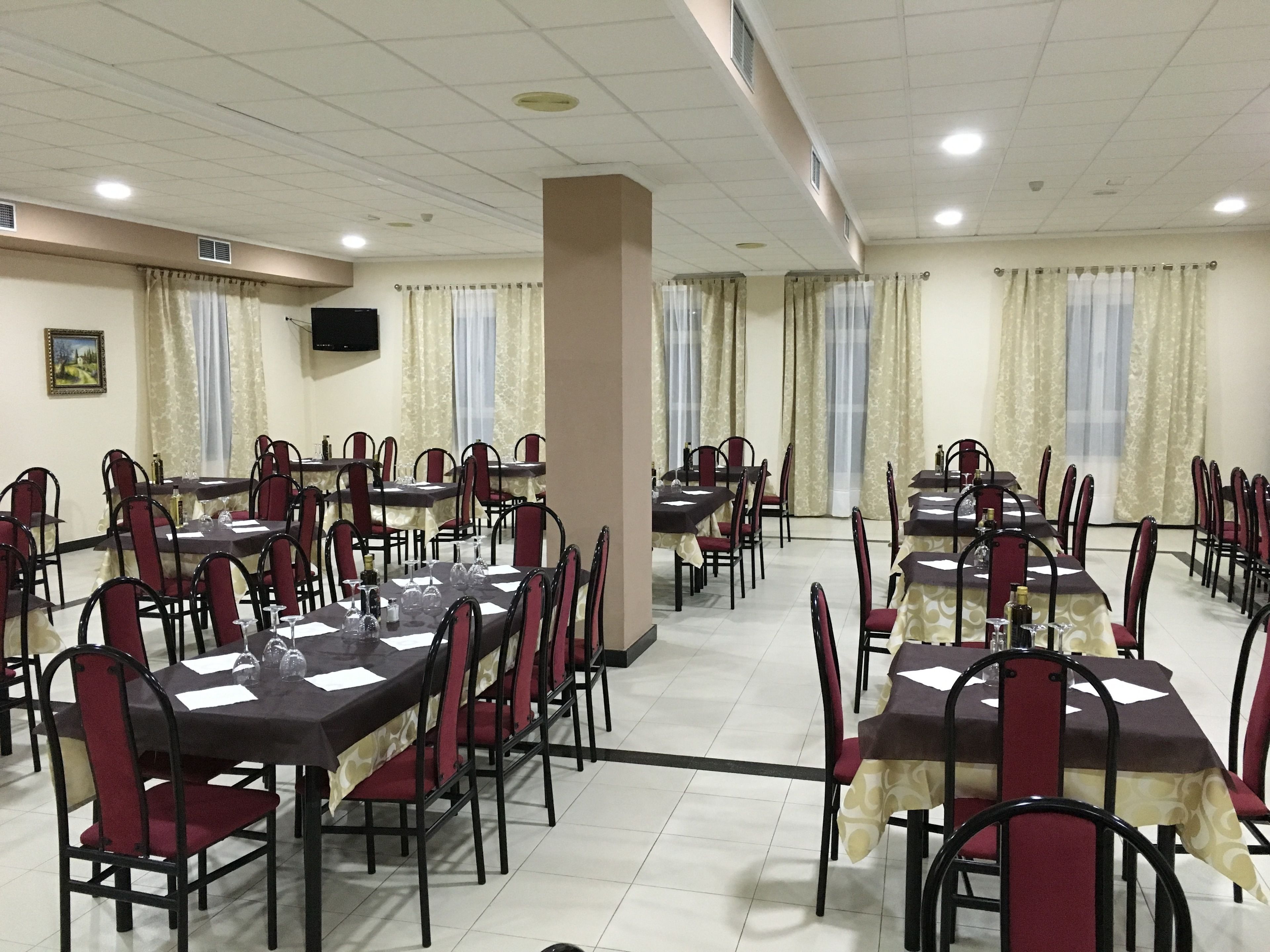 A dining area with multiple tables and chairs, arranged in rows.