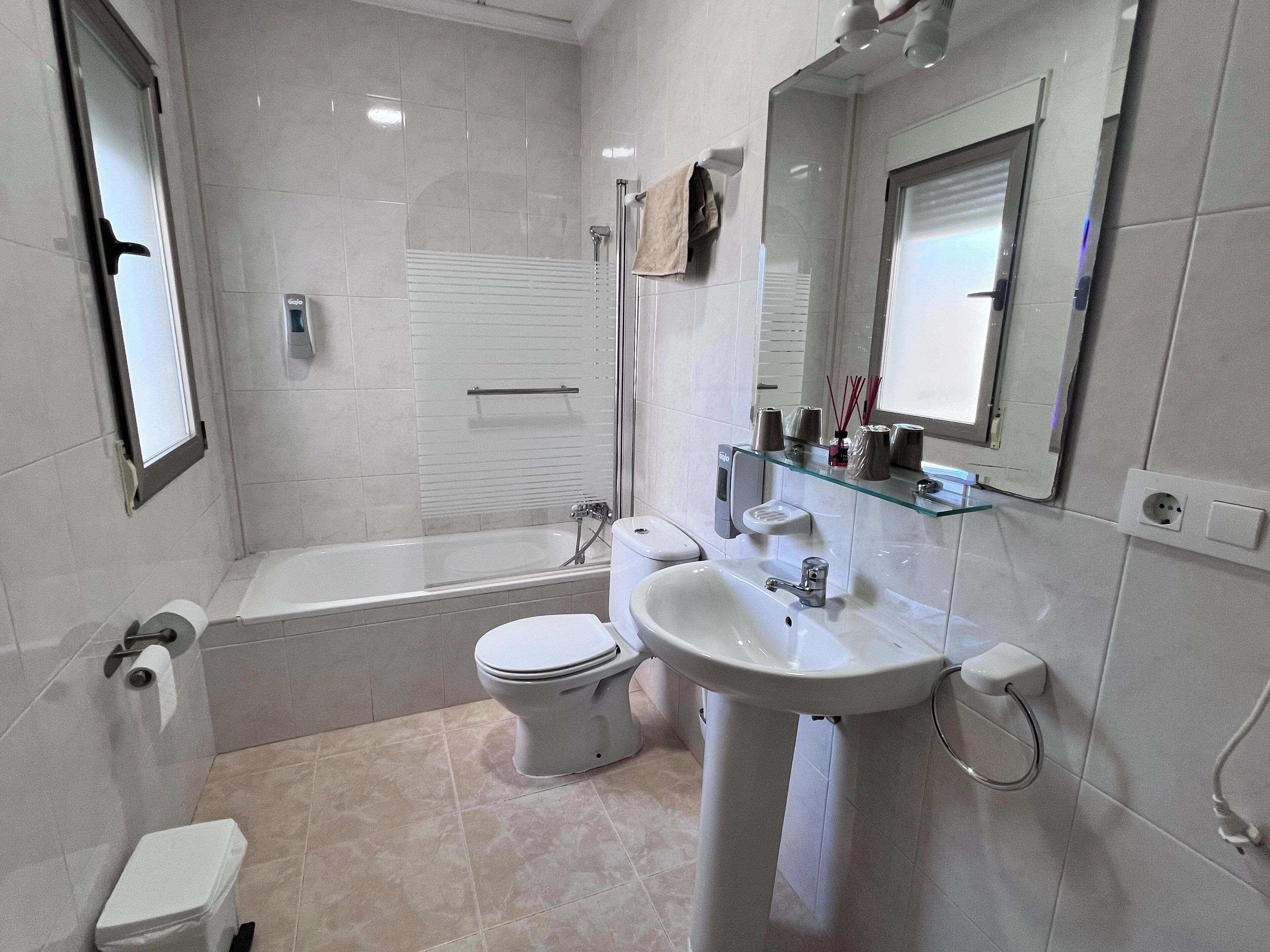 A modern bathroom with a bathtub, toilet, and sink.