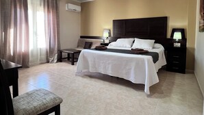 Een hotelkamer met een bed, nachtkastjes, een bureau en een stoel.
