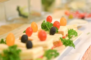 A buffet with various food items including bread, tomatoes, and olives. - Hoang Phu Gia (Ho Chi Minh City)