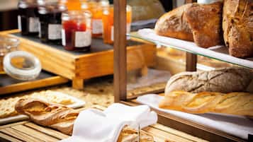 Una vitrina de panadería con panes y pasteles varios.