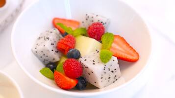 Eine Schüssel Obstsalat mit Erdbeeren, Blaubeeren, Himbeeren und Drachenfrucht.