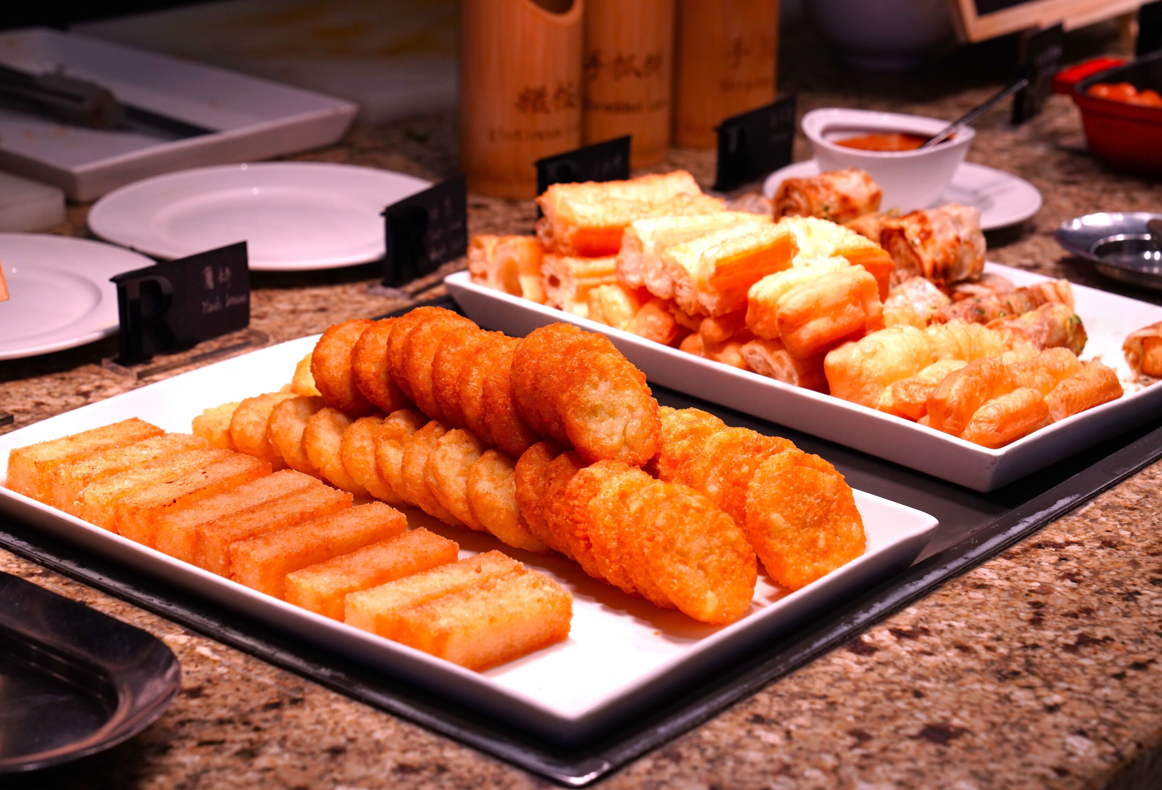 A buffet with various dishes including fried items and bread.