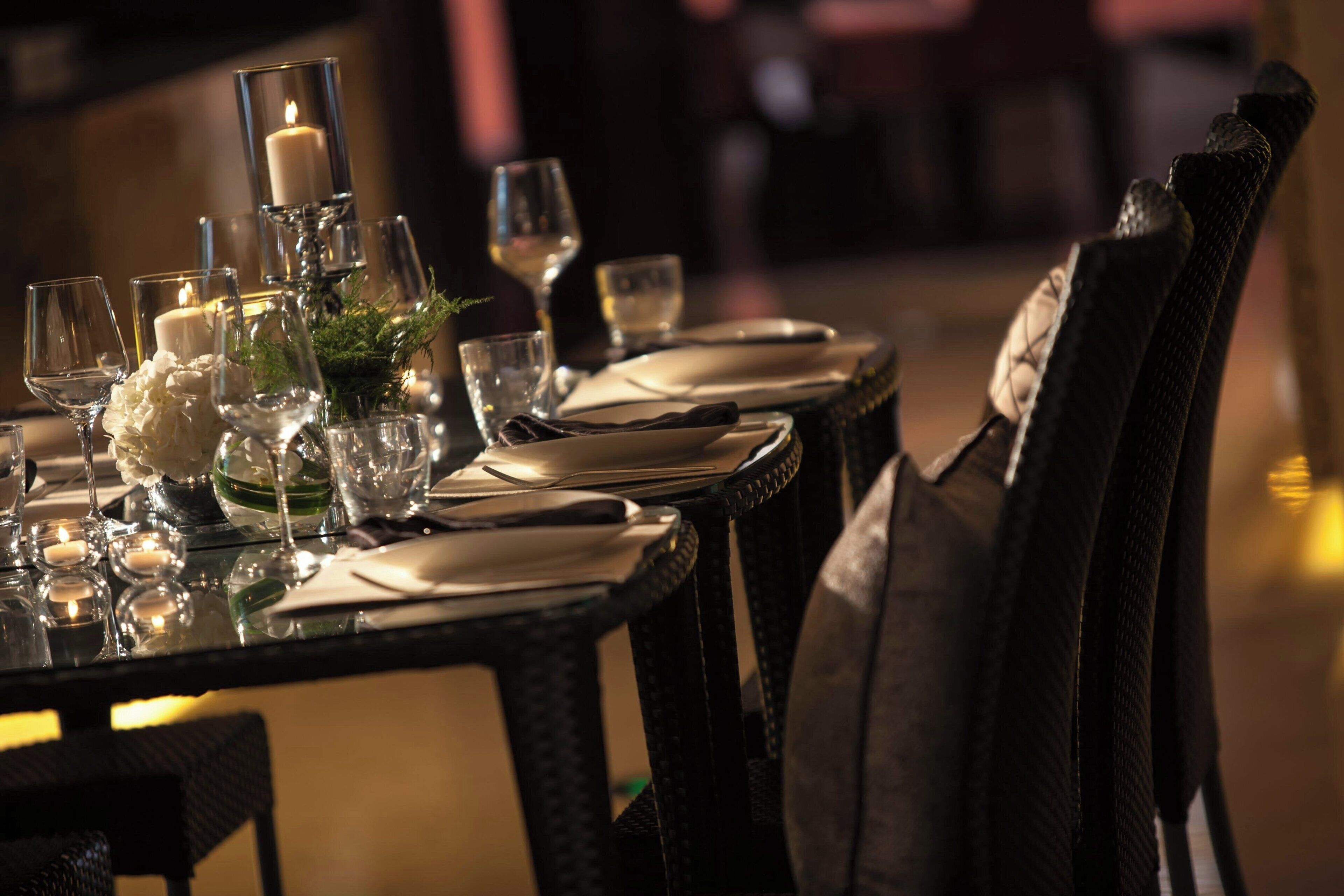A table set for dining with candles, glasses, and plates.