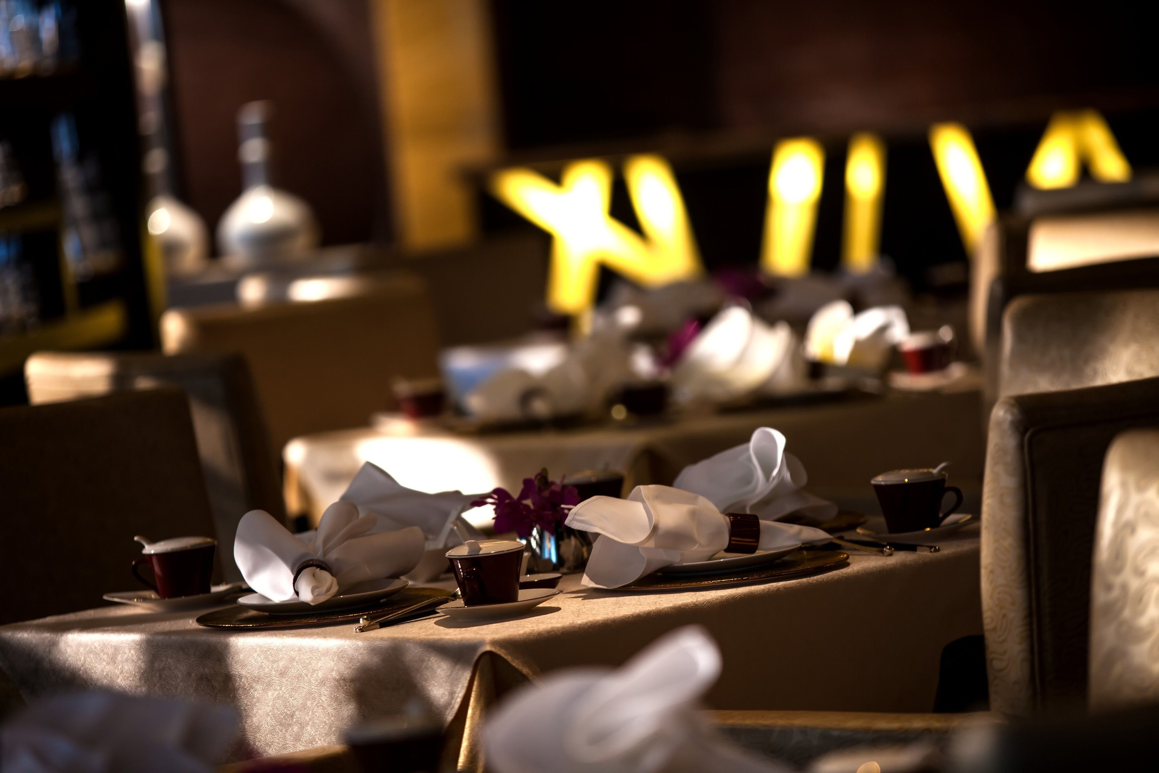 Ein Restaurant mit gedeckten Tischen, einschließlich Teller, Tassen und Besteck.