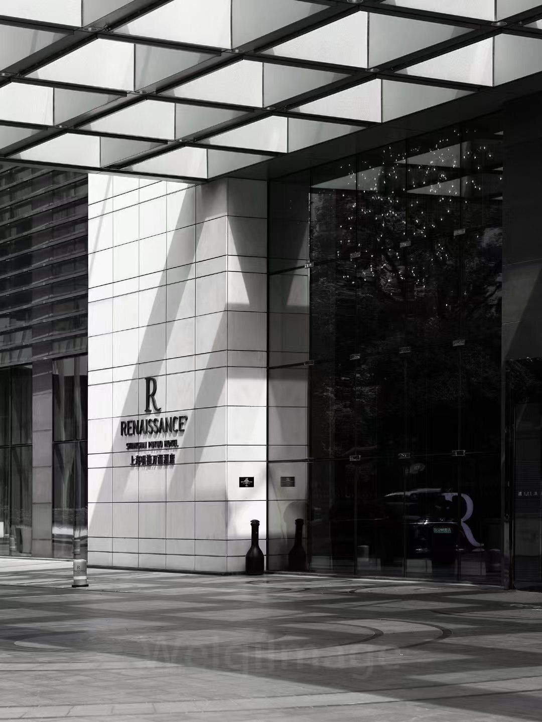 A modern building facade with a prominent 'Renaissance' sign, geometric window patterns, and a reflective glass entrance.