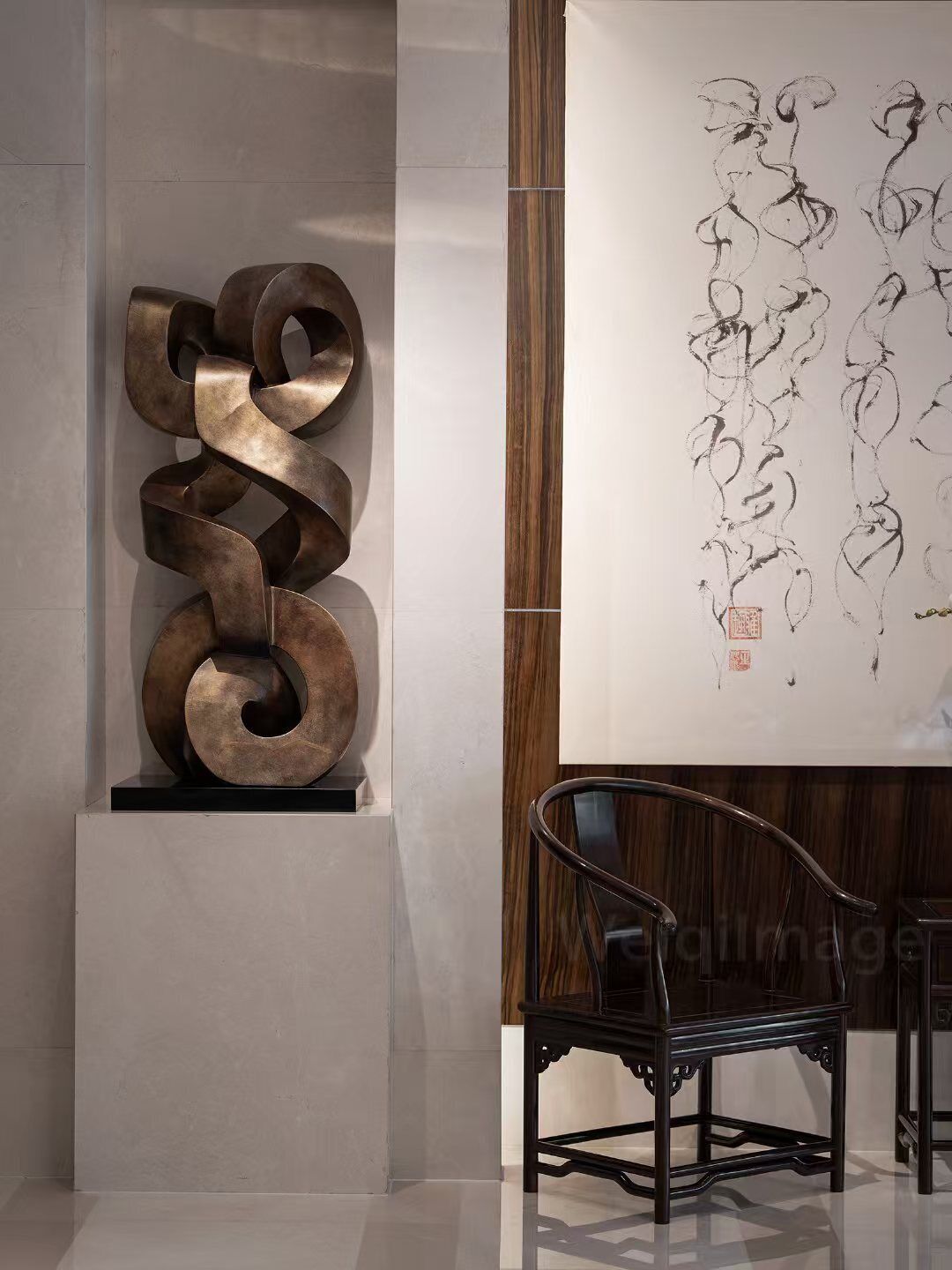 Een modern interieur met een metalen abstracte sculptuur, een traditioneel kalligrafisch kunstwerk en een klassieke houten stoel.