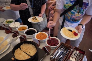 A buffet with various dishes and utensils. - Emeraude Classic Cruises (Tuan Chau)