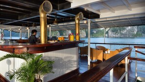 A bar area with a counter, bar stools, and a view of the water.