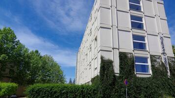 A multi-story building with a modern architectural design, featuring a series of windows and a visible entrance.
