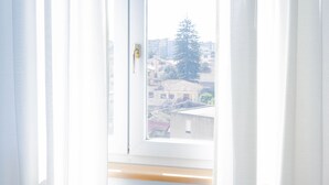 Une chambre avec une fenêtre, des rideaux et un lit.