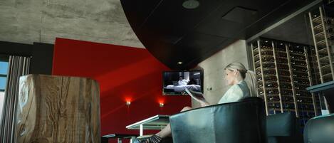 Un interior moderno con un gran poste de madera, asientos de cuero negro, una pared de acento roja y una estantería para vinos.