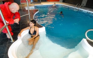 Una piscina techada, sillones reclinables de piscina