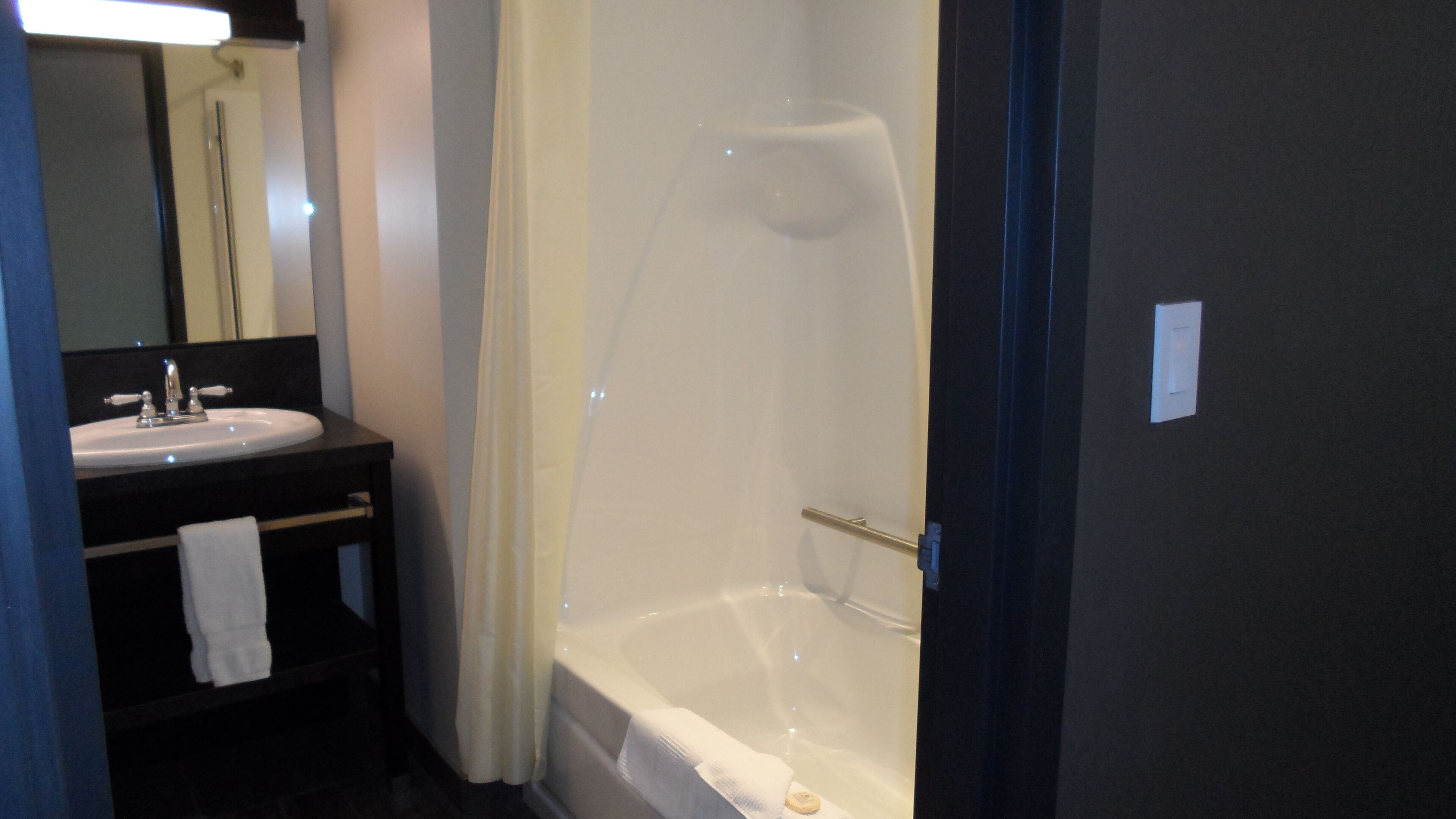Un baño con lavamanos, espejo y bañera.