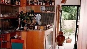 Une cuisine compacte avec un coin repas, comprenant une horloge, divers ustensiles de cuisine et une plante en pot.