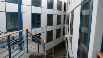 A multi-level building with a central staircase, large windows, and a blue and white color scheme.
