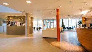 A modern lobby with a reception desk, seating area, and a Christmas tree. - Asa Spa Hotel (Kuressaare)
