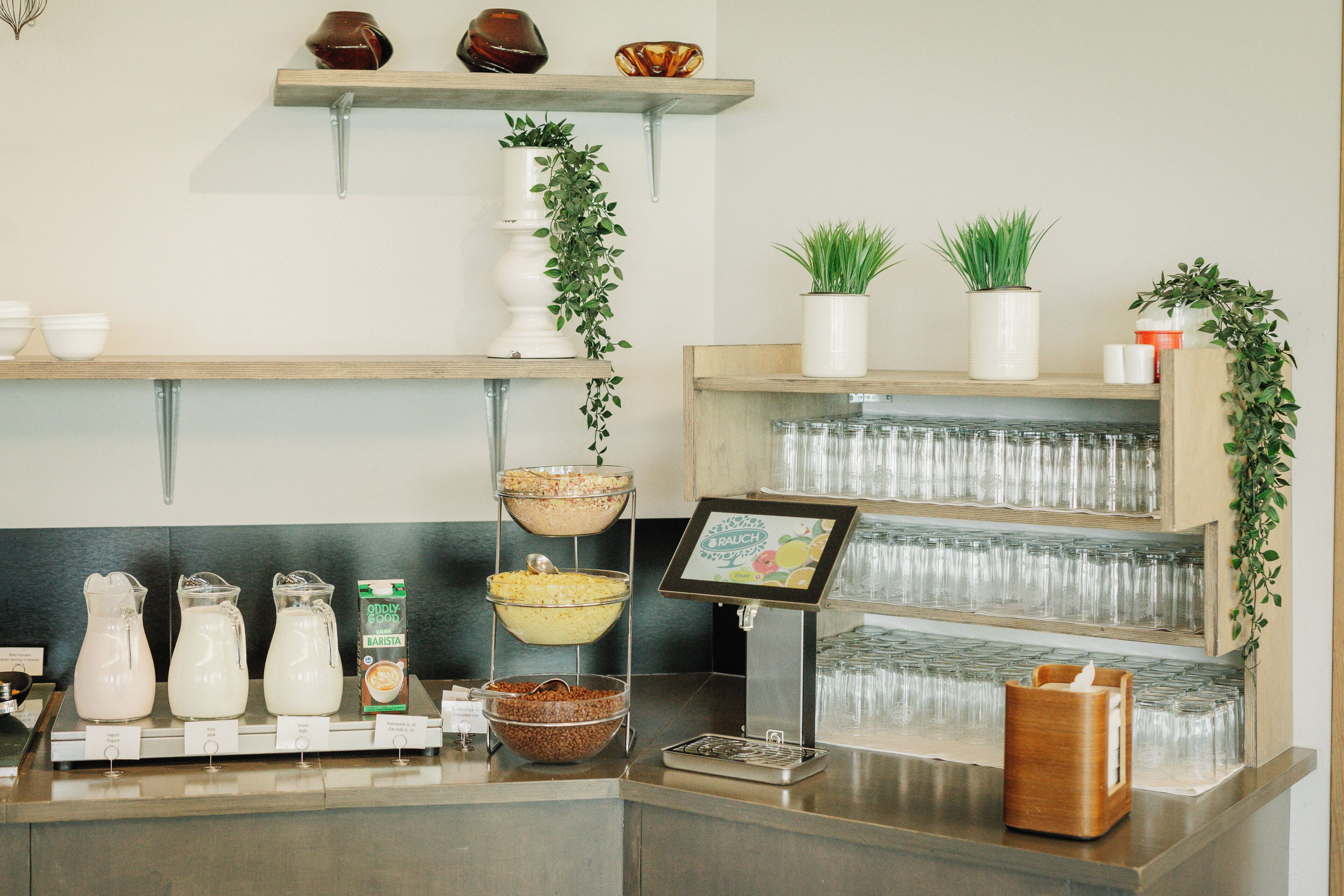 Zona de bar con estantes que exhiben vasos, una cafetera y una variedad de productos lácteos.