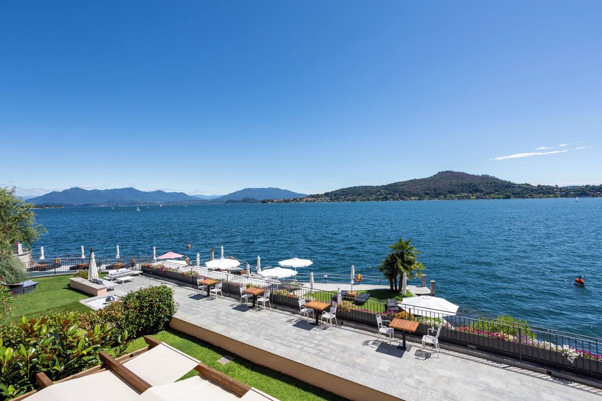 Une terrasse au bord de l’eau, avec des sièges extérieurs et une vue sur le lac.