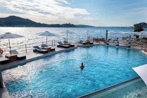 Una piscina al aire libre de temporada, sombrillas