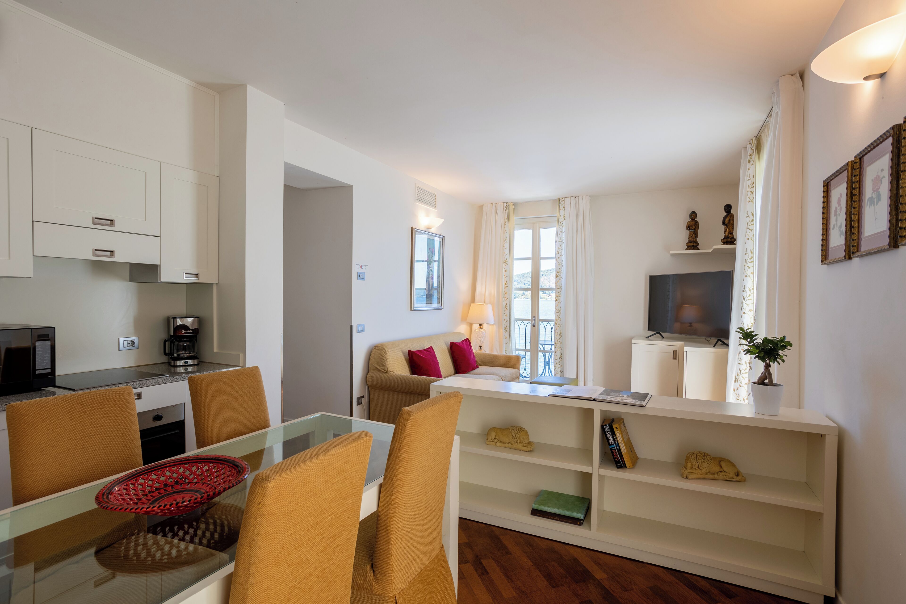 A compact living space with a kitchenette, a dining area, a sofa, and a TV.