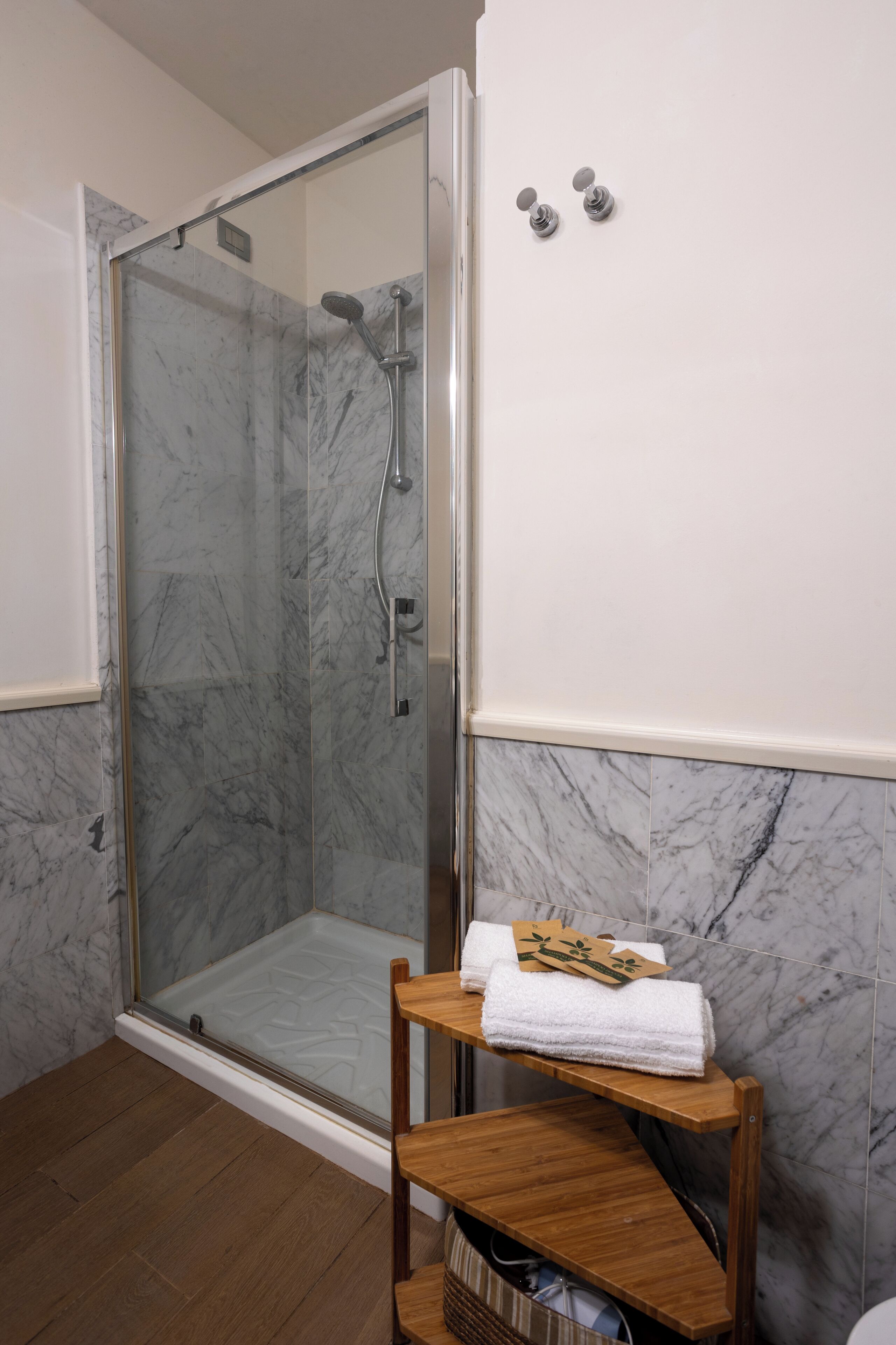 Eine gläserne Dusche mit einem hölzernen Ablagebereich für Handtücher.