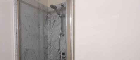 Eine gläserne Dusche mit einem hölzernen Ablagebereich für Handtücher.
