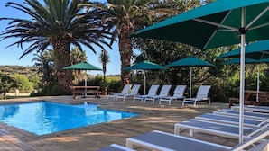 A poolside area with lounge chairs and umbrellas.