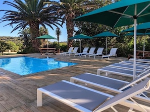 A poolside area with lounge chairs and umbrellas. - Oyster Bay Lodge (Oyster Bay)